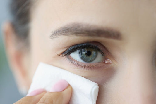 Woman using an eyelid wipe to clean her eyes