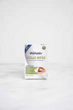 The front of a box of Blephadex Eyelid Wipes with Tea Tree Oil & Coconut Oil in a bathroom.