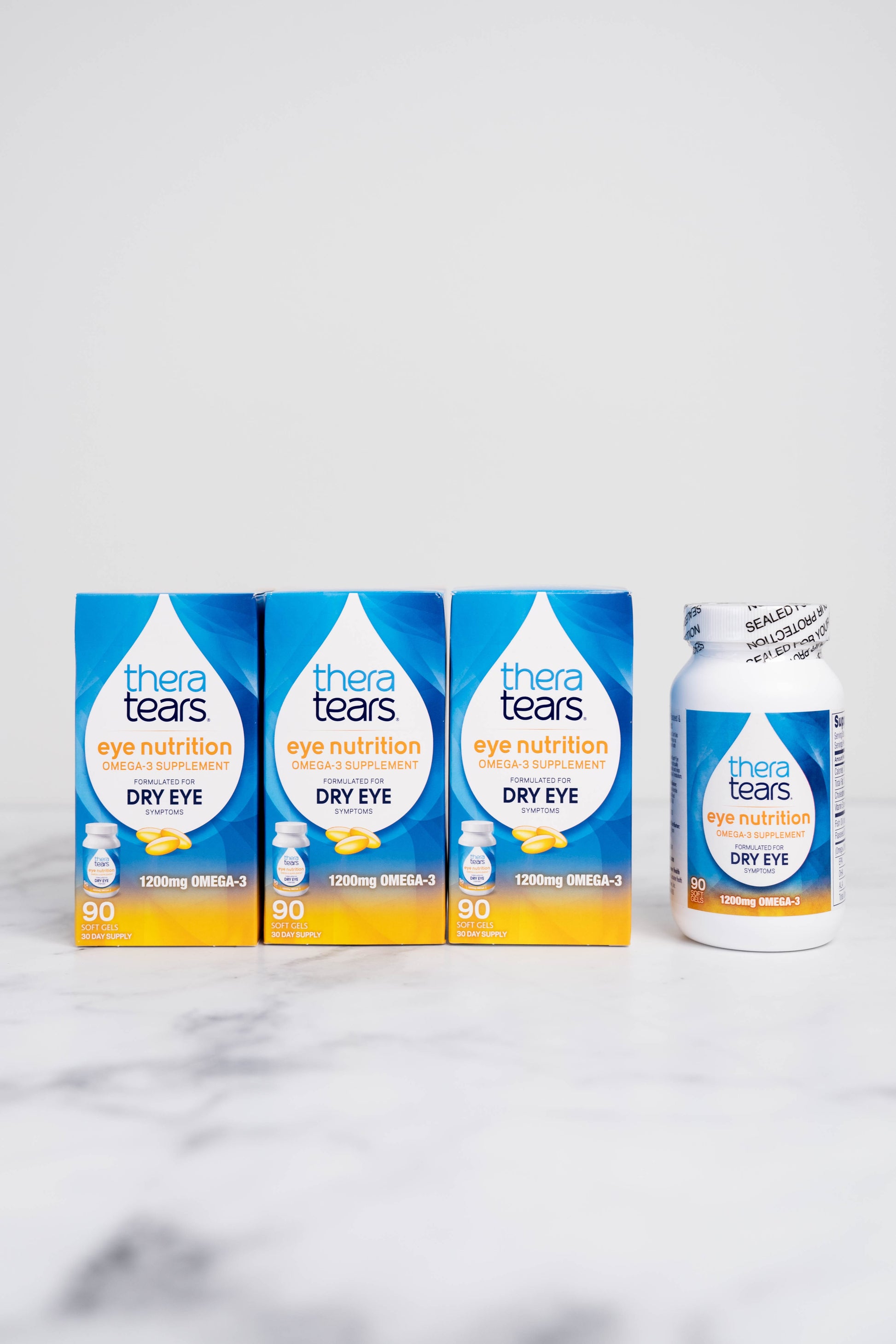 A bottle and 3 boxes of TheraTears Eye Nutrition for Dry Eyes. Each bottle contains 90 capsules.