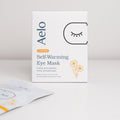 A box of Aelo Self Warming Eye Mask with Chamomile on a light grey background.